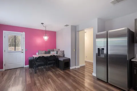 a kitchen with stainless steel appliances kitchen island granite countertop a stove refrigerator and cabinets