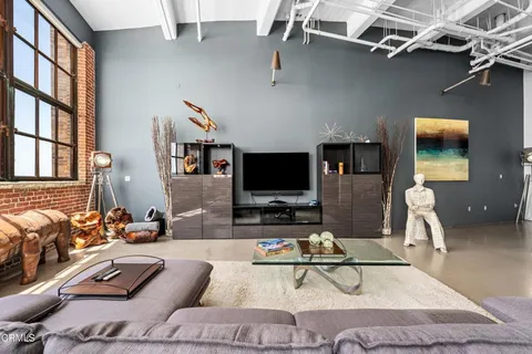 a living room with furniture a flat screen tv and a large window