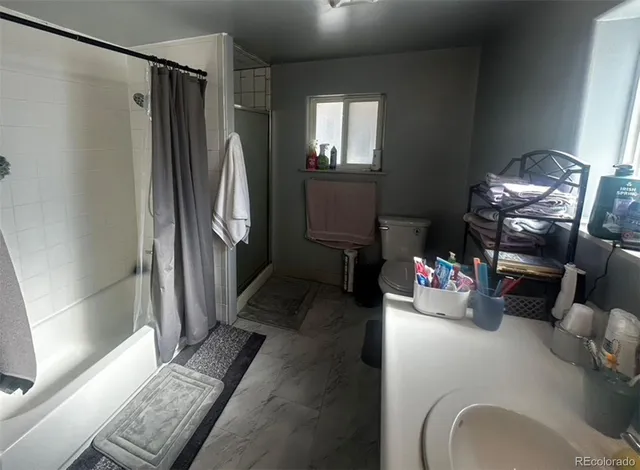 a hallway with a couch and a dining table with wooden floor