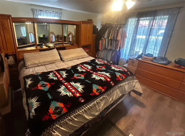 a bedroom with a bed window and mirror