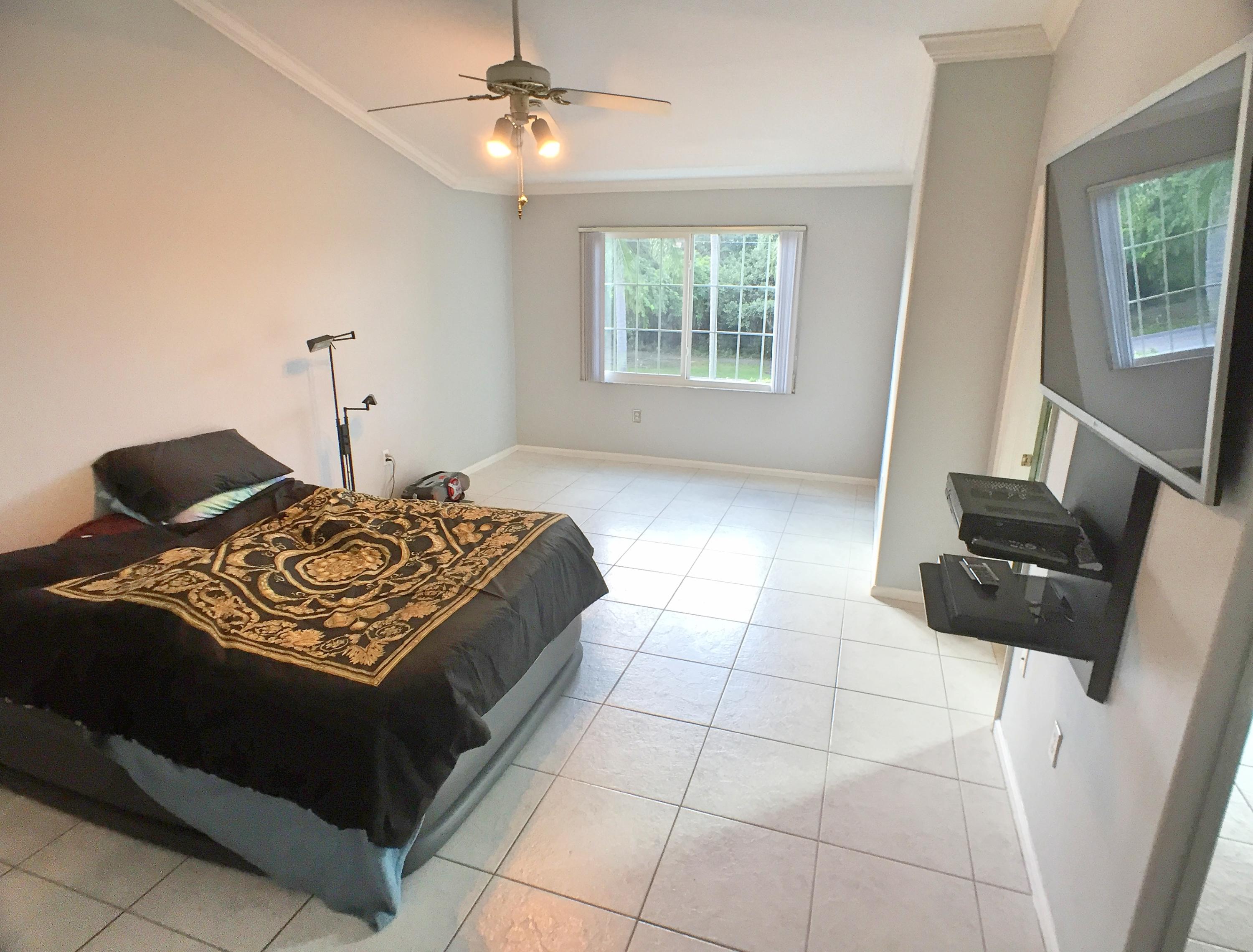 9378 Boca River Circle Boca Raton, FL 33434 - Photo 14 of 28 a bedroom with a bed and a television