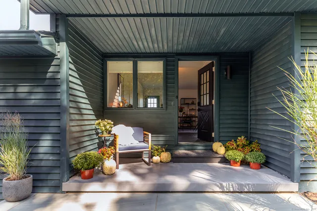 a view of a patio with table and chairs potted plants