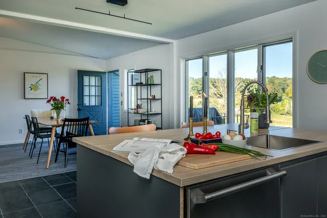 a kitchen with stainless steel appliances a table chairs in it and wooden floors