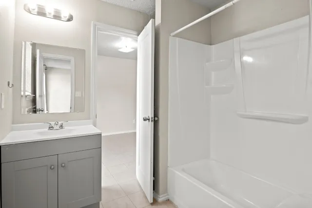 a bathroom with a bathtub sink vanity and mirror