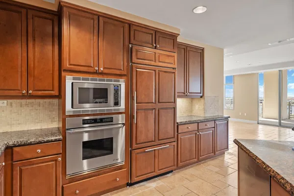 a kitchen with stainless steel appliances granite countertop a refrigerator and cabinets