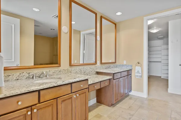a bathroom with a granite countertop sink and a mirror