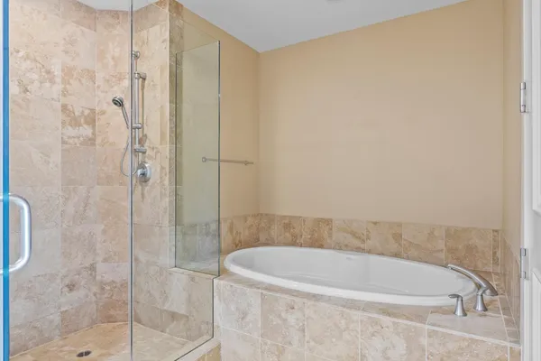 a white bath tub sitting next to a shower