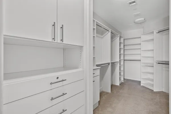 a view of walk in closet with empty racks