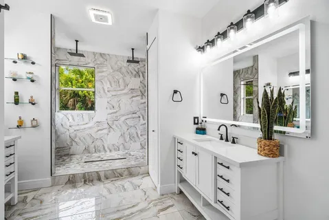 a bathroom with a double vanity sink mirror and shower