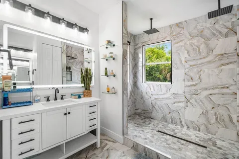 a bathroom with a double vanity sink mirror and shower