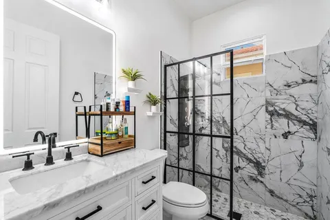 a bathroom with a sink a toilet and shower