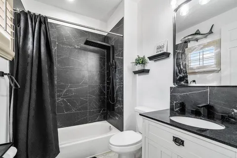 a bathroom with a granite countertop sink toilet and shower