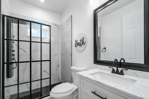 a bathroom with a sink a toilet and shower