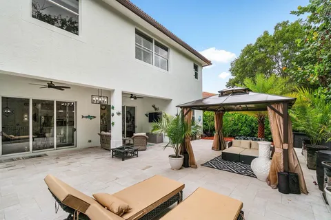 a backyard of a house with table chairs and couches