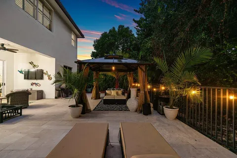 a view of a patio with table and chairs potted plants and floor to ceiling window
