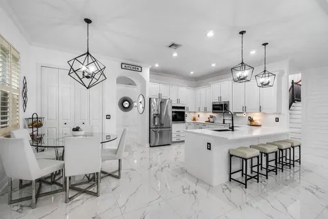 a large kitchen with a table and chairs