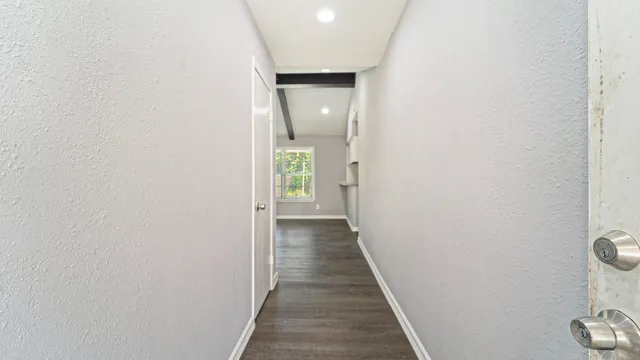 a view of a hallway with wooden floor