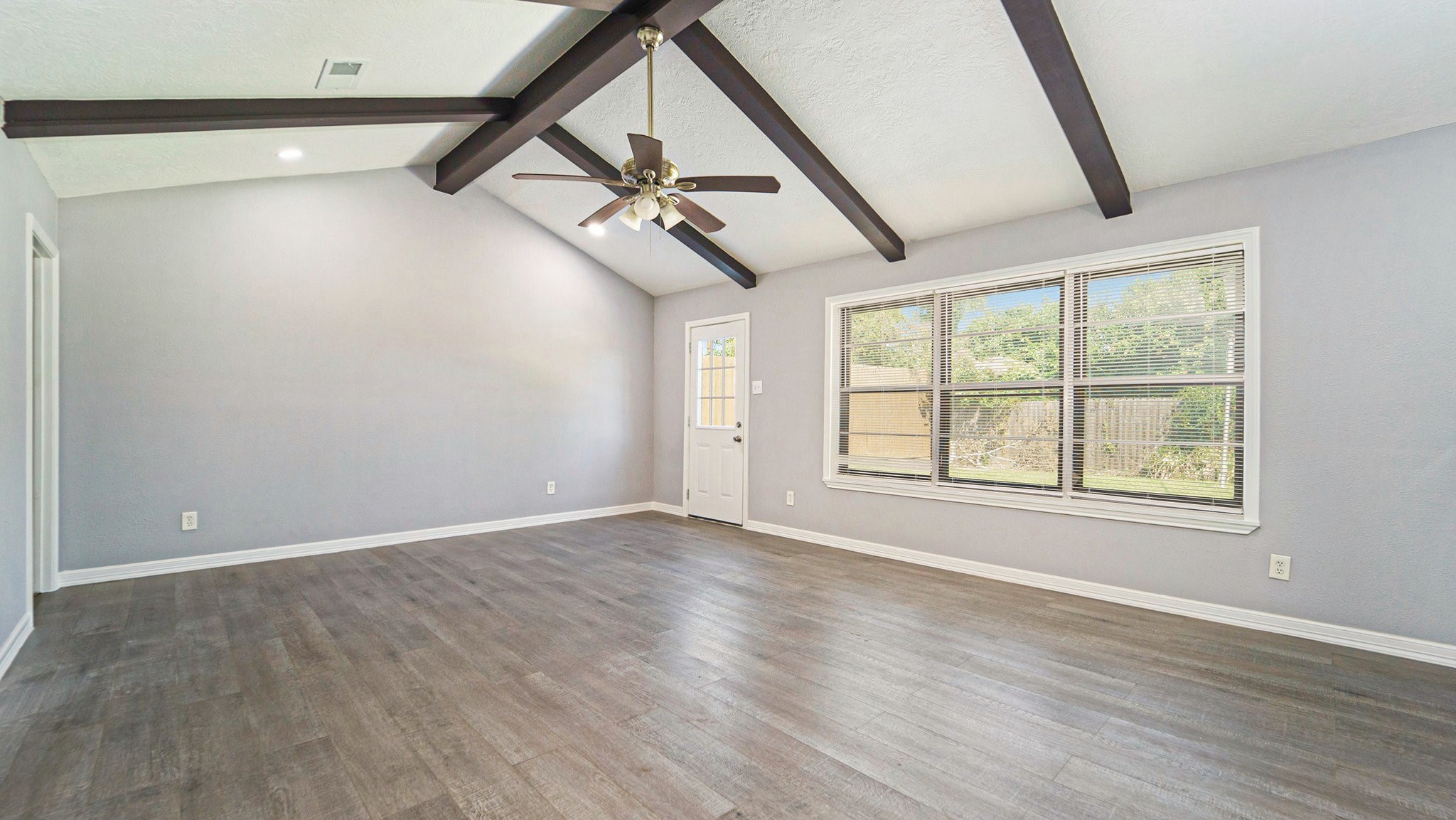 3008 Columbia Street Baytown, TX 77521 - Photo 4 of 23 a view of an empty room with wooden floor and a window