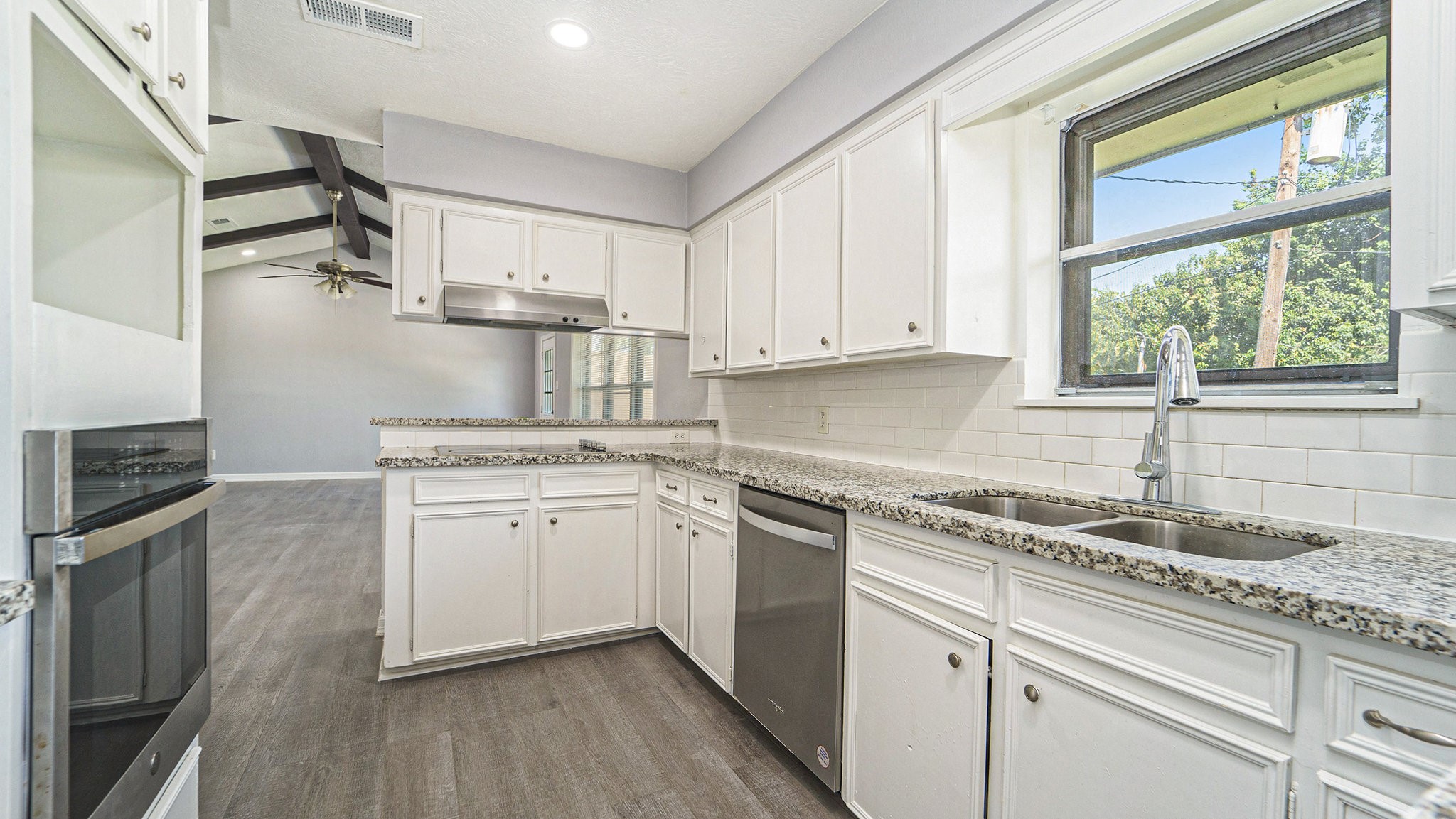 3008 Columbia Street Baytown, TX 77521 - Photo 5 of 23 a kitchen with granite countertop white cabinets white appliances a sink and a window