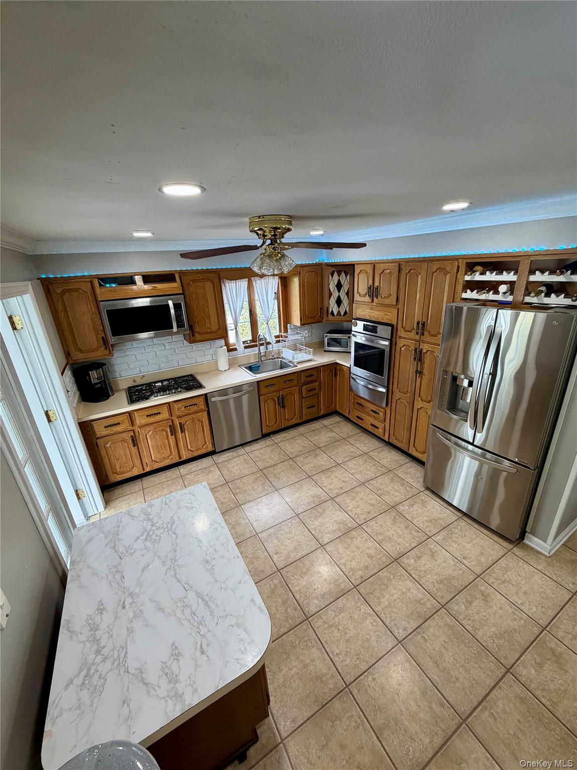 27 Colonial Road Copiague, NY 11726 - Photo 5 of 15 a kitchen with stainless steel appliances granite countertop a refrigerator and a stove