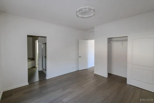 an empty room with wooden floor and closet