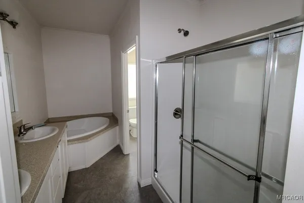 a bathroom with a granite countertop bathtub shower and toilet