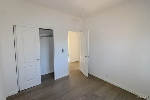 a view of an empty room with wooden floor
