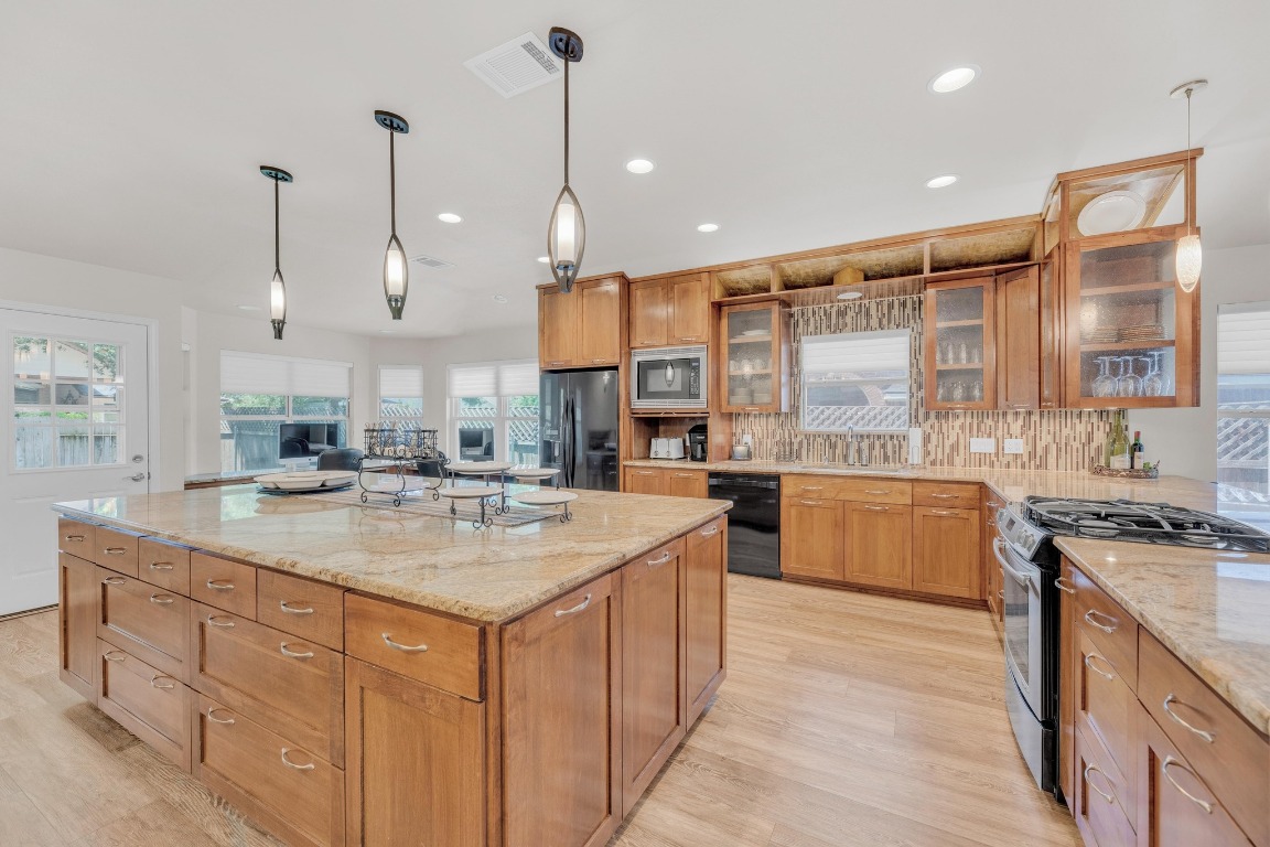 815 Clarence Bohl Pflugerville, TX 78660 - Photo 1 of 1 a kitchen with kitchen island a counter top space a sink stainless steel appliances and a large window