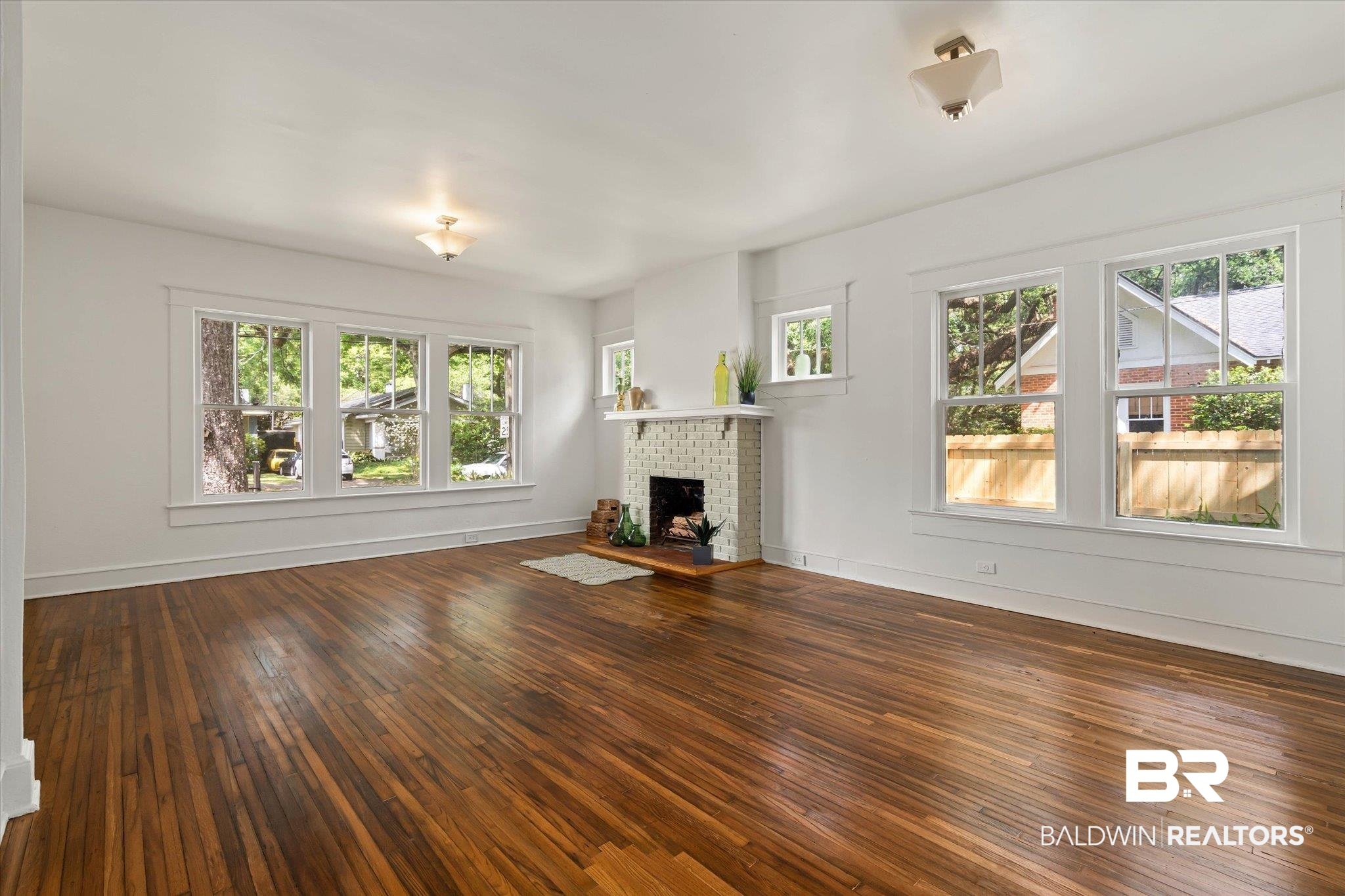121 Westwood Street Mobile, AL 36606 - Photo 5 of 20 Unfurnished living room with hardwood / wood-style flooring, a healthy amount of sunlight, and a fireplace