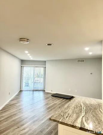 an empty room with wooden floor and window