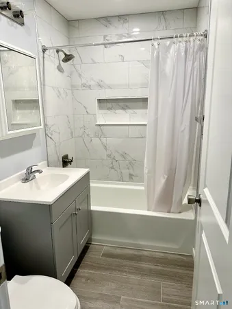a bathroom with a sink and mirror with bathtub