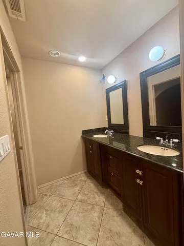 a bathroom with a double vanity sink and mirror