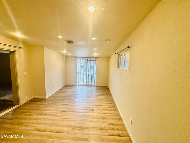 a view of a hallway with wooden floor