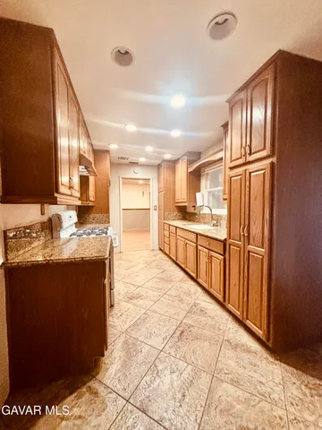 a kitchen with stainless steel appliances granite countertop a refrigerator and a sink
