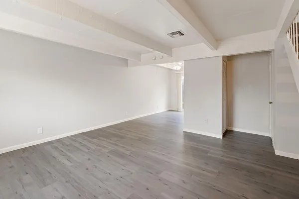 a view of an empty room with wooden floor