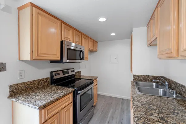 a kitchen with stainless steel appliances granite countertop a sink stove and microwave