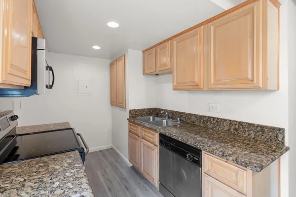 a kitchen with stainless steel appliances granite countertop a sink stove and cabinets