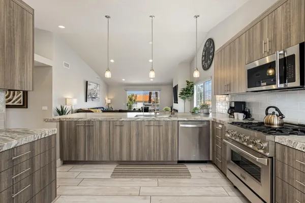 a kitchen with stainless steel appliances granite countertop a stove a sink a microwave and cabinets