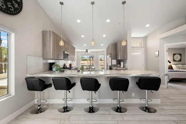 a kitchen with a dining table chairs sink and granite counter top