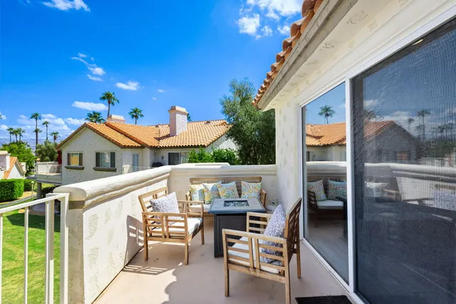 a view of a patio with table and chairs with wooden floor and fence