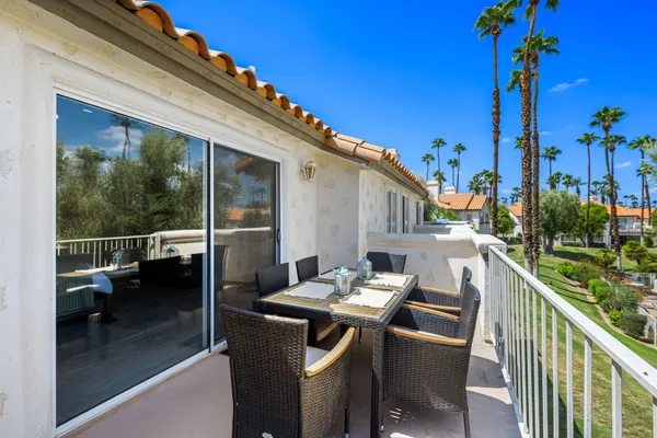 a view of a patio with table and chairs potted plants with wooden floor and fence