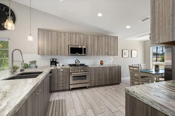 a kitchen with granite countertop a sink stove and cabinets