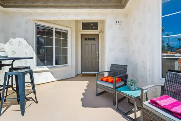 a view of a patio with table and chairs with wooden floor and fence