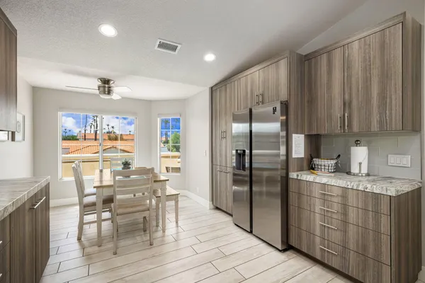 a kitchen with stainless steel appliances granite countertop a refrigerator and wooden cabinets