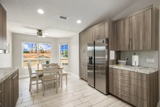 a kitchen with stainless steel appliances granite countertop a refrigerator and wooden cabinets