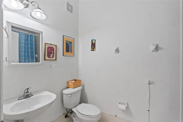 a bathroom with a toilet a sink and mirror