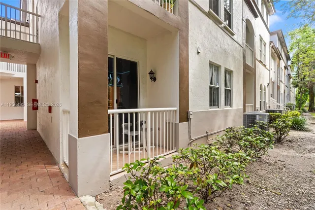 a view of a house with a small yard and flower plants