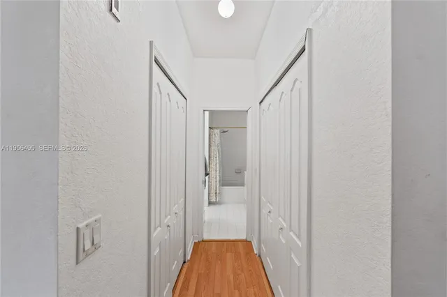 a view of a hallway with wooden floor and staircase