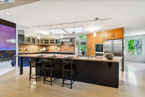 a kitchen with granite countertop a table chairs stove and cabinets