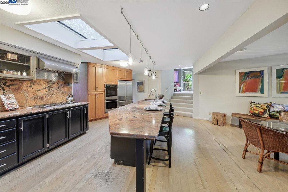 391 Oak Lane Pleasanton, CA 94566 - Photo 25 of 60 a kitchen with stainless steel appliances kitchen island granite countertop a table chairs and a refrigerator